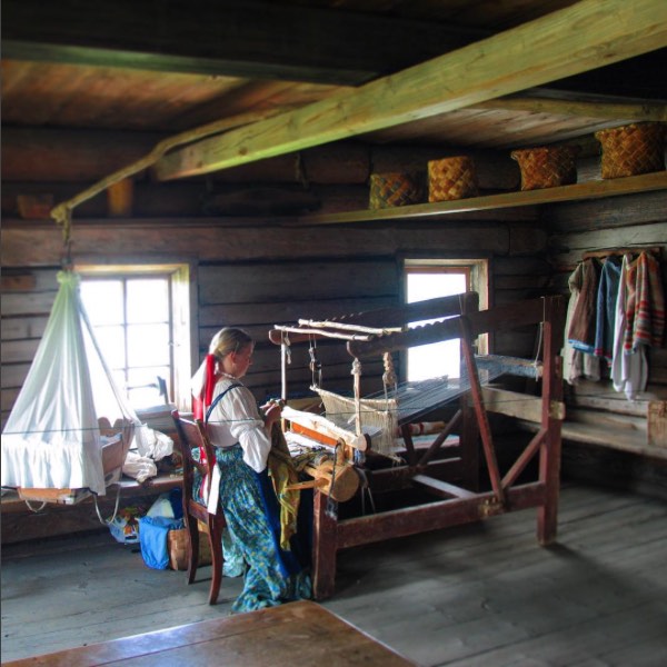 A Kizhi: una ragazza all'interno di una casa tesse abiti locali